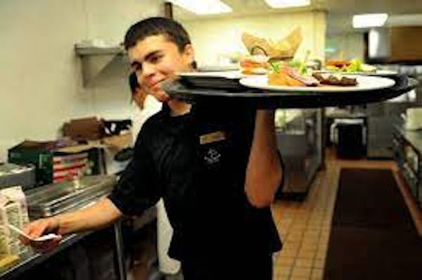 Person carrying tray in restaurant environment