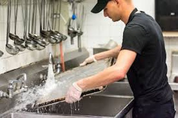 Person rinsing a baking pan 