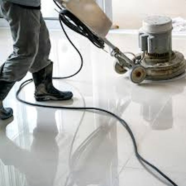 Leg shot of a person pushing a floor buffer on white floors