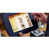 Hand using a touch screen POS system with Panera items