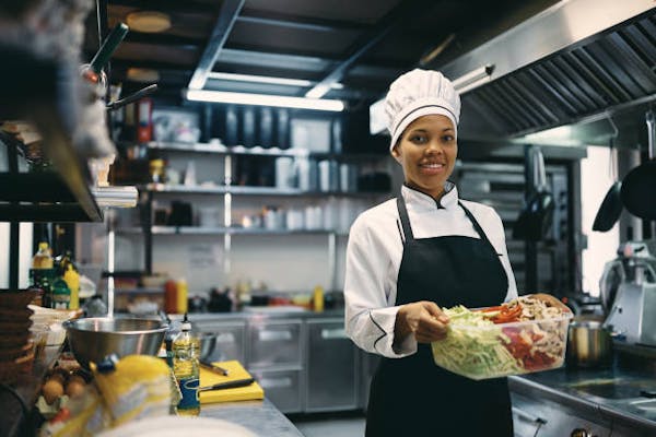 Female Chef carrying prepped food items 