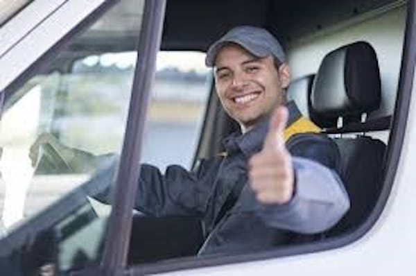 Person driving a van to pick people up for rides.