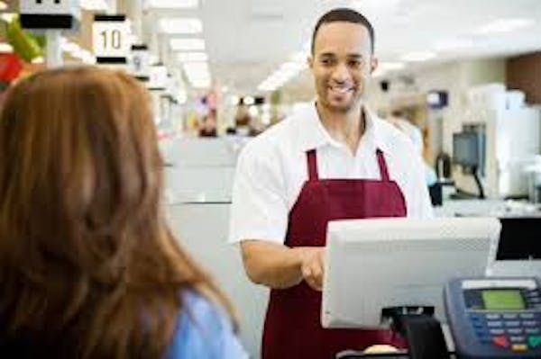 Person smiling at a register to a customer