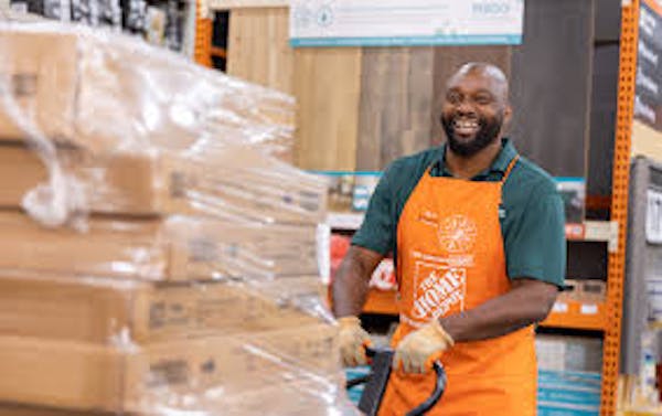 Person in Home Depot pushing pallet of boxes