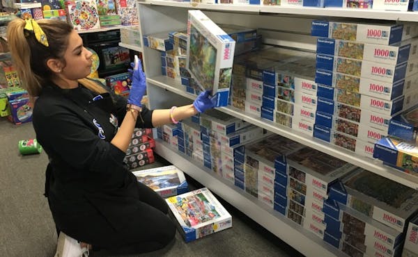 Woman stocking shelf with toys