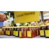 Jars of honey on table with a "Local honey" sign above