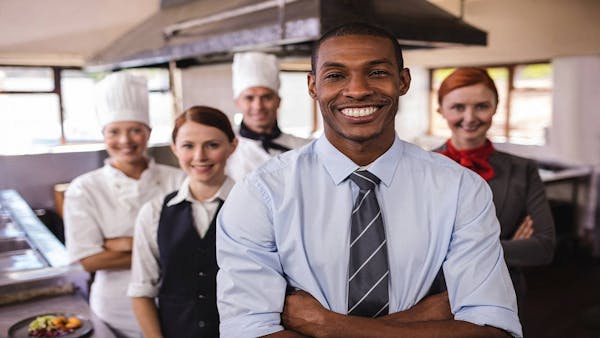 Group of people in various uniforms (culinary, housekeeping, professional)