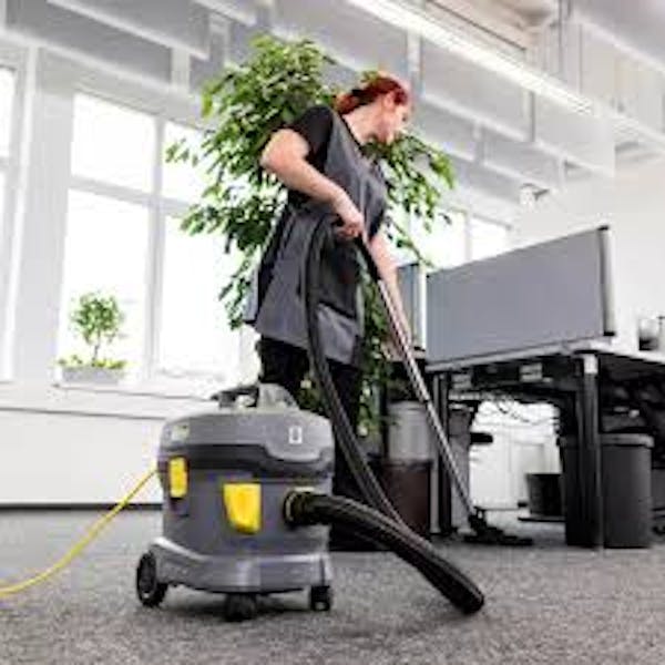 Person vacuuming in an office setting