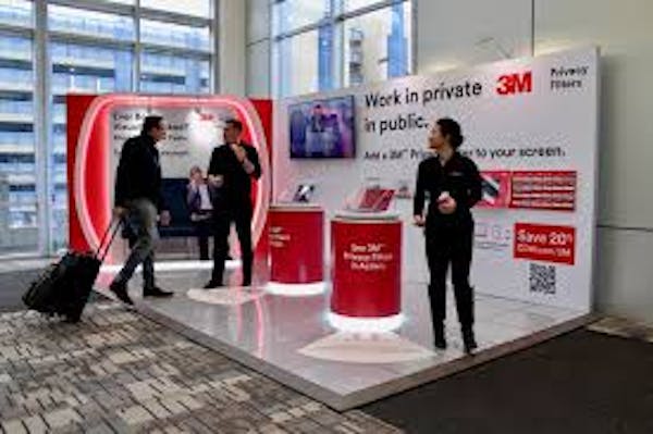 Two individuals working at a kiosk for promotional items at an event