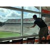 Person cleaning windows inside a suite at football stadium