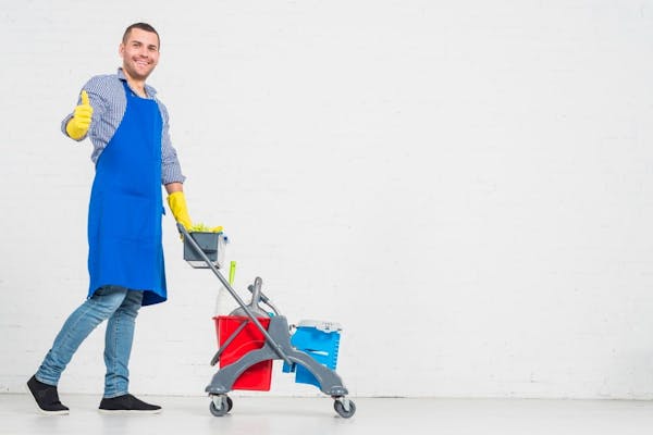 Man pushing cart with cleaning supplies giving a thumbs up