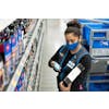 Person with handheld scanner pulling items from shelves for shipment