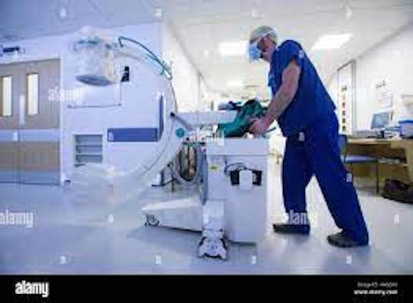 Person pushing medical equipment in hospital setting