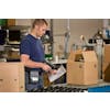 Person working in warehouse setting packing boxes for shipment