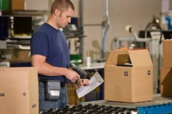 Person working in warehouse setting packing boxes for shipment